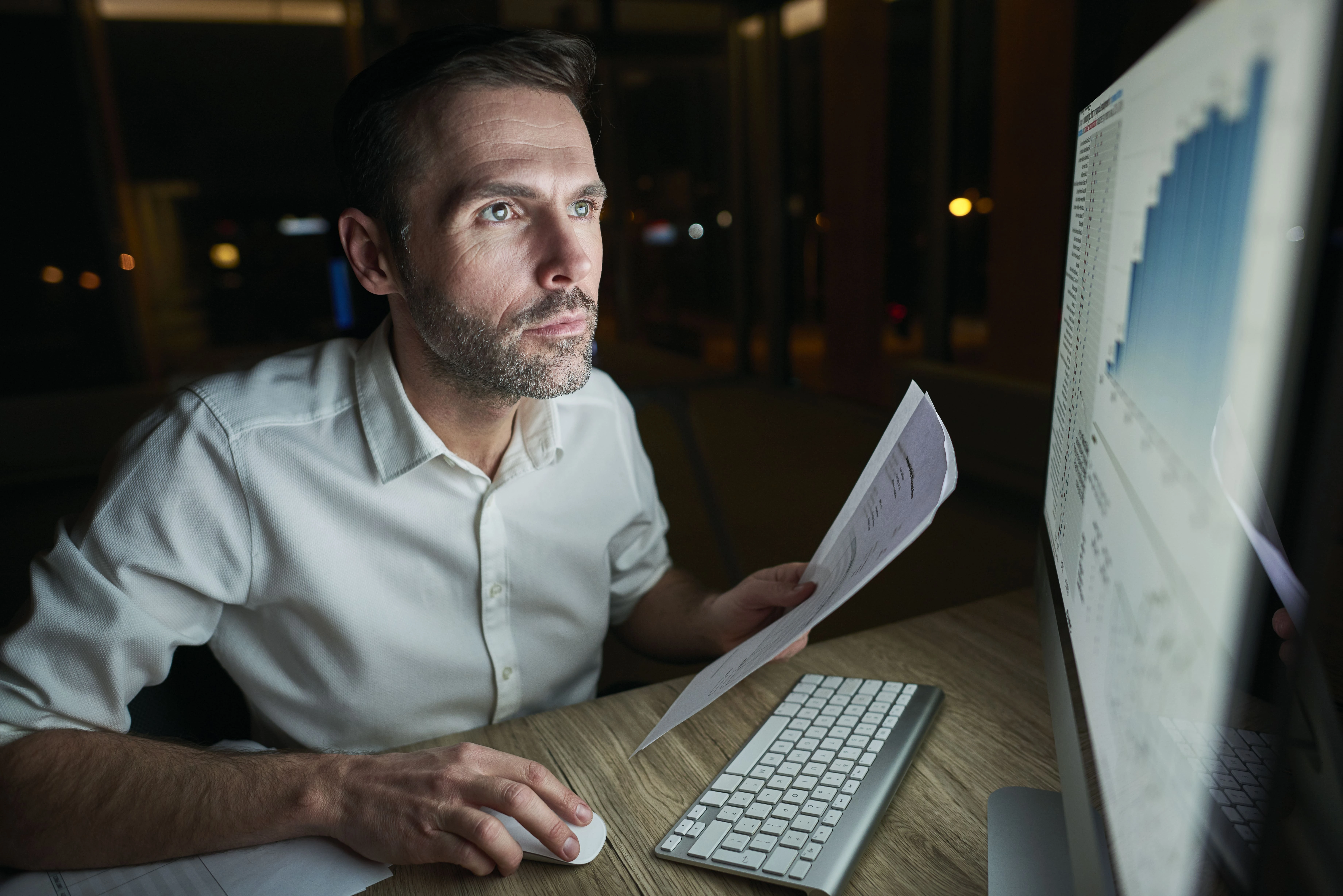 focused-man-with-document-using-computer (2).webp