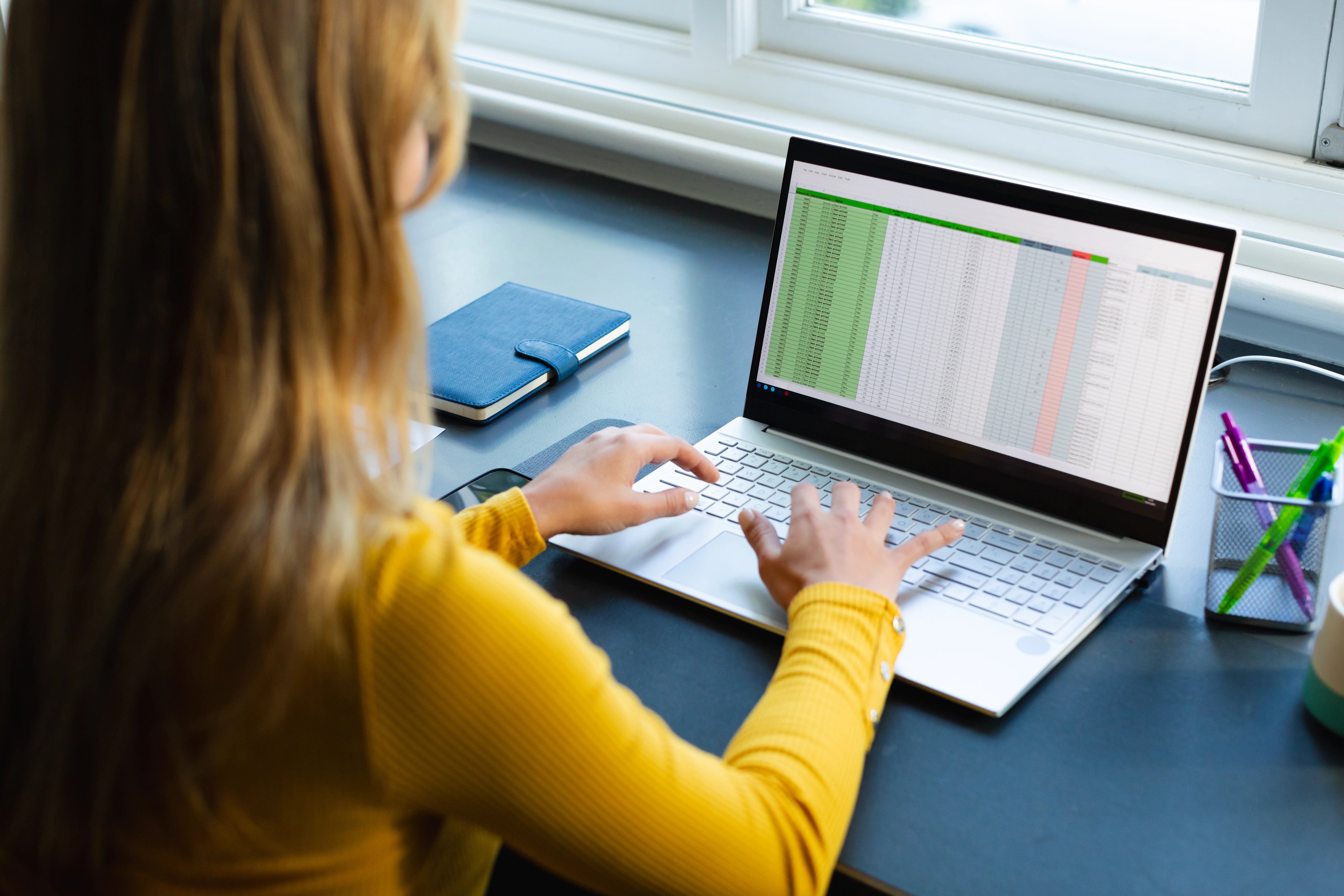 focused-caucasian-woman-sitting-desk-working-from-home-using-laptop-sunny-room.webp